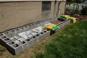 Newspaper lines the bottom of the garden bed to keep weeds from coming through the bottom.